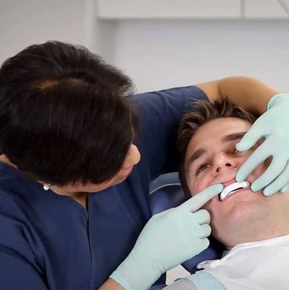 Dentist checking the fit of a sleep apnea oral appliance