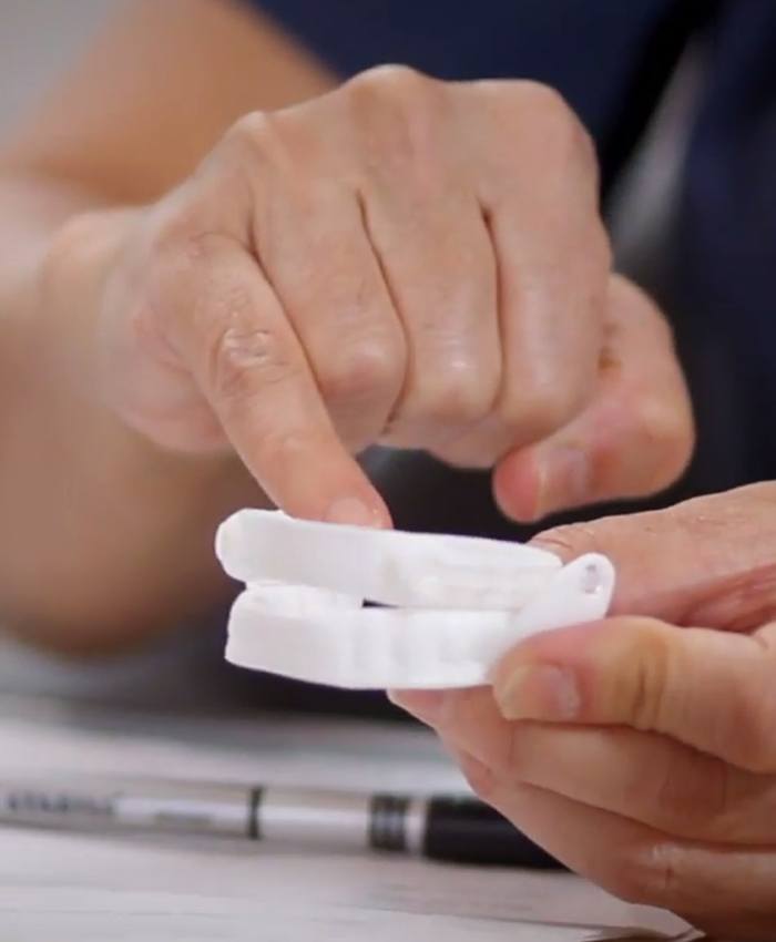 Dentist showing patient a sleep apnea oral appliance