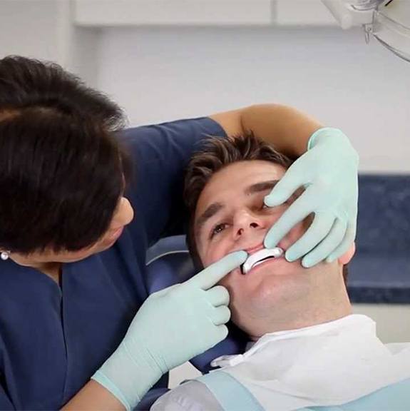 Sleep apnea dentist checking the fit of patient's oral appliance