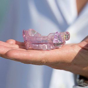 Hand holding oral appliance for sleep apnea