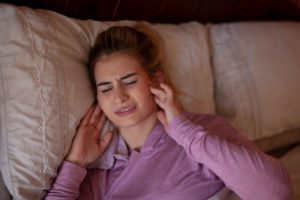 Woman with jaw pain, suffering from TMJ and sleep apnea in Denver